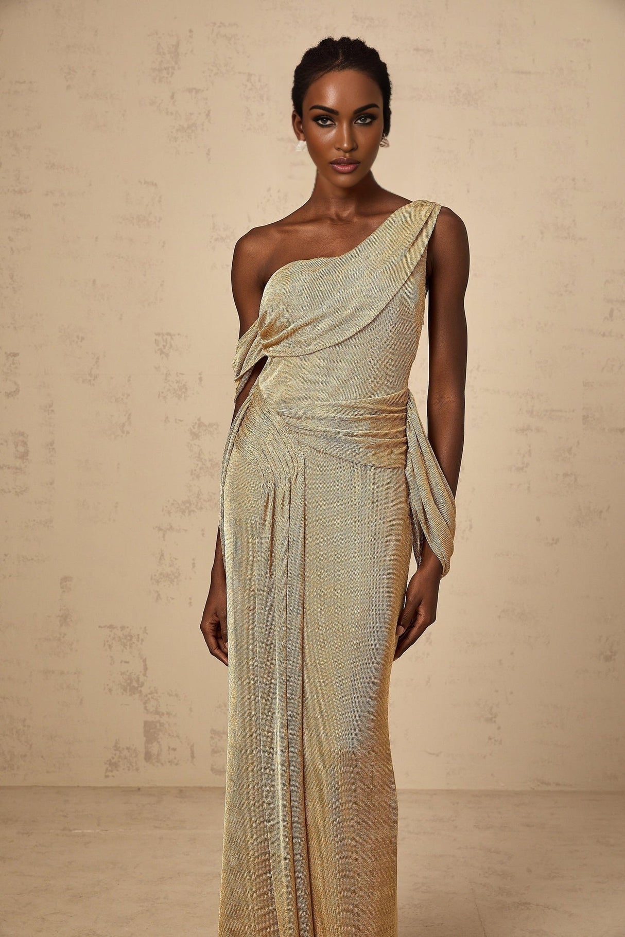 A long gold maxi dress with a gathered design and ribbon details named Anne