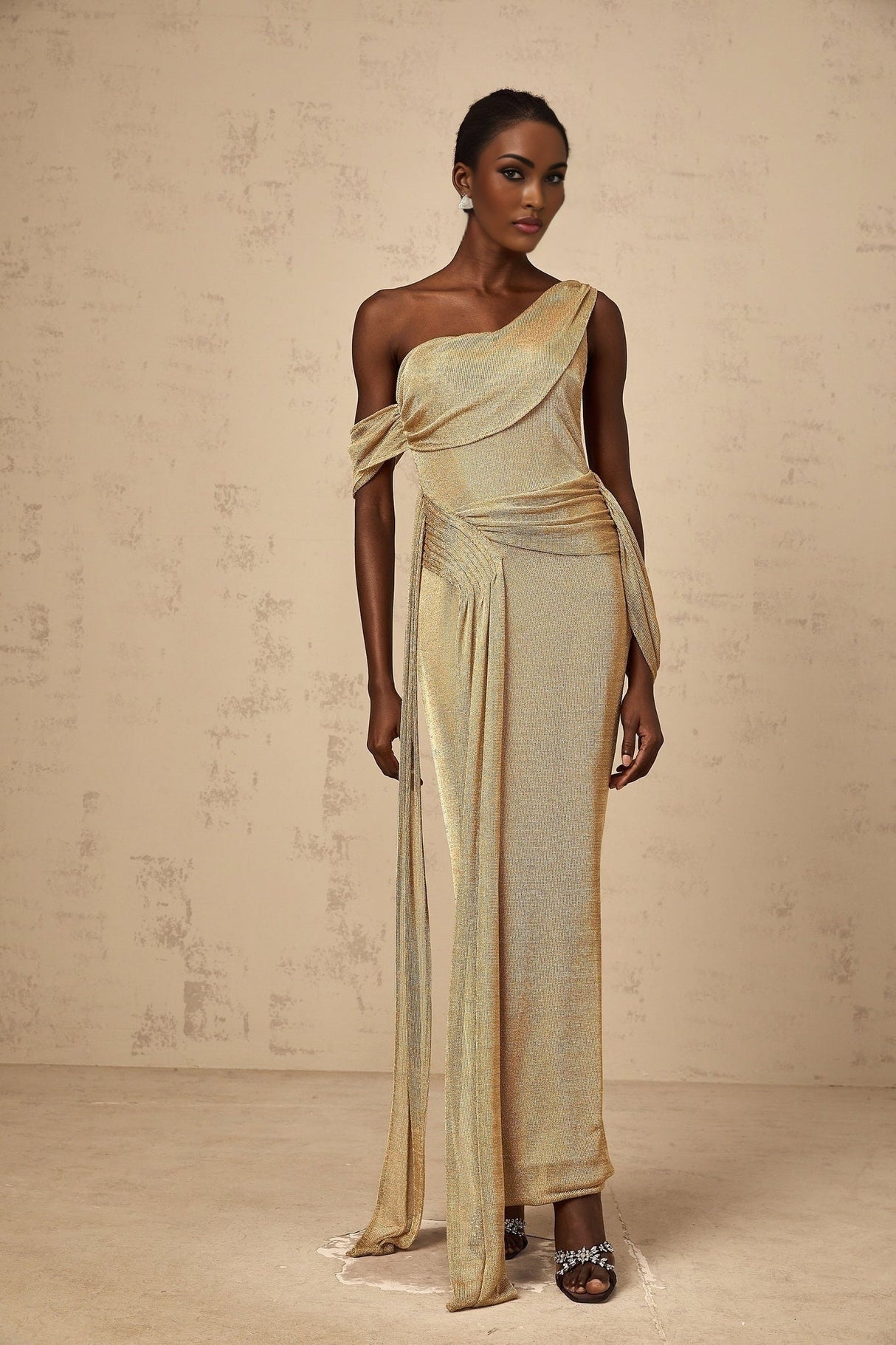 A long gold maxi dress with a gathered design and ribbon details