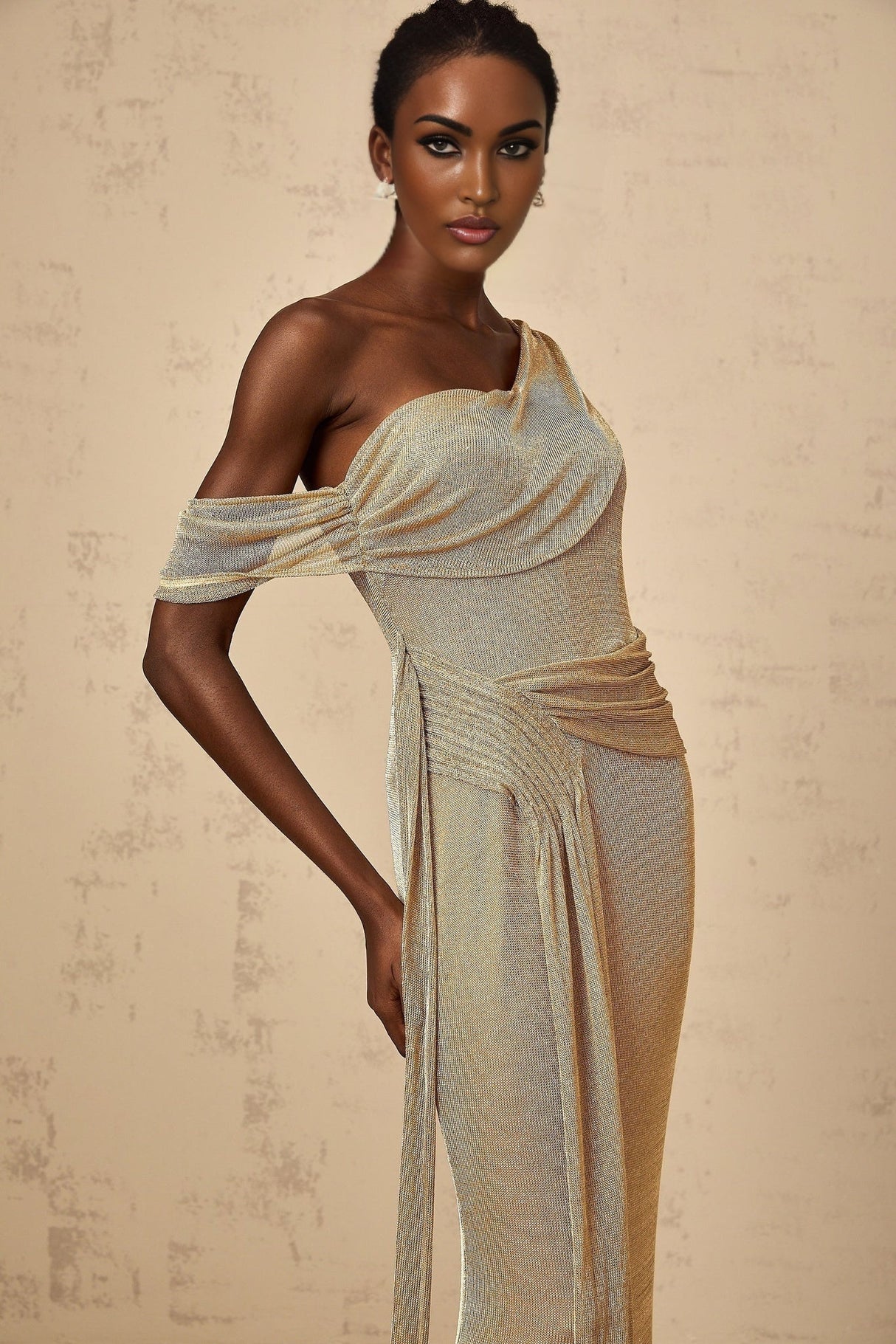 A long gold maxi dress with a gathered waist and ribbon design details
