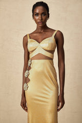 A long golden maxi dress with floral cutout patterns and a flowing silhouette named Giulia