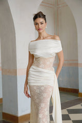 A long maxi dress featuring floral lace panels and neutral colored ribbon details with a delicate romantic design