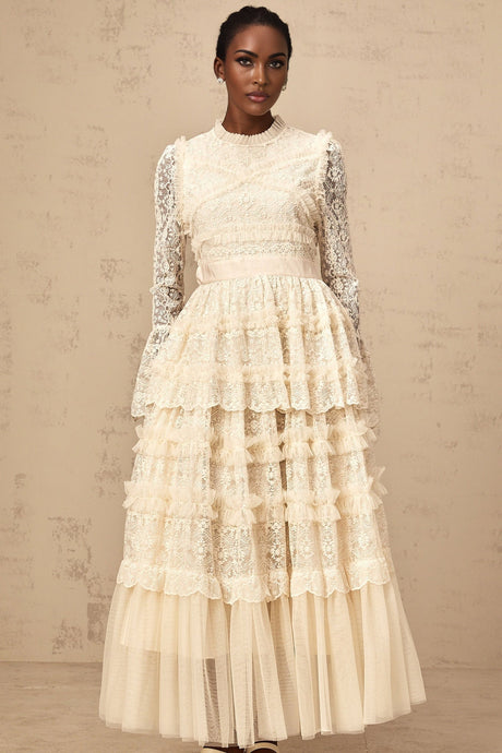A long neutral colored maxi dress with lace panels and ruffled tulle details