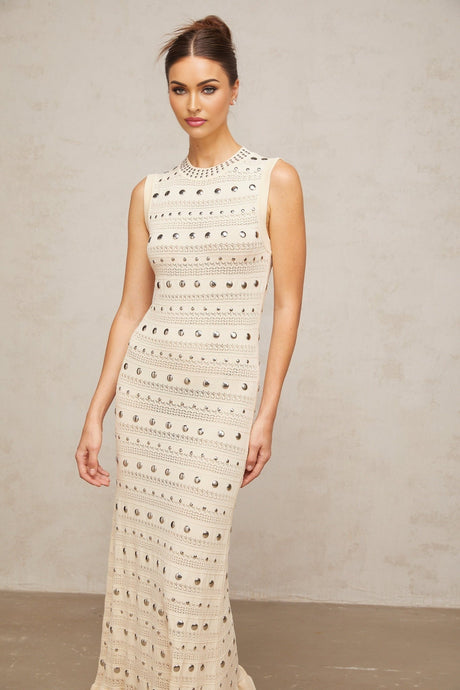 A long neutralcolored maxi dress with crochetknit pattern and studded details made by Chloé