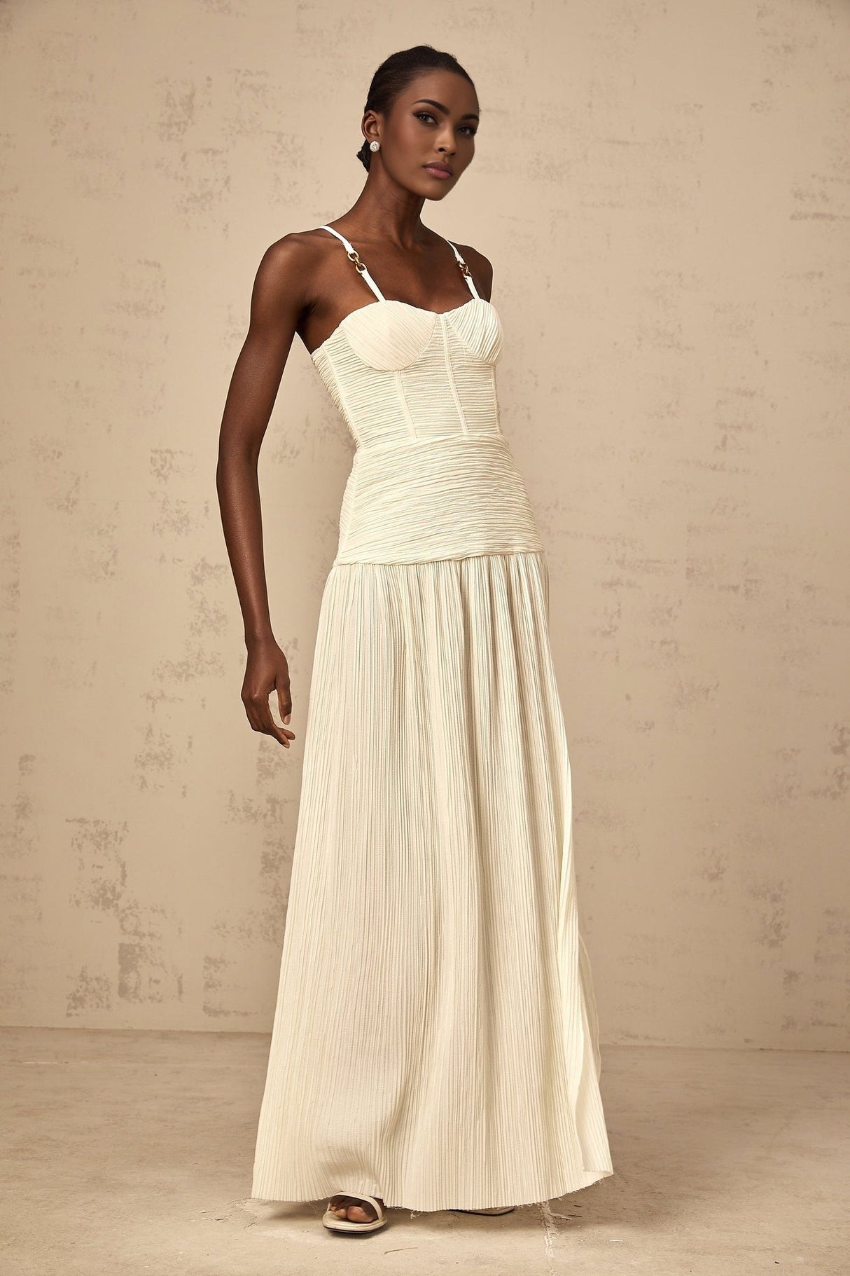 A long neutralcolored maxi dress with side slits and pleated details named Felicie