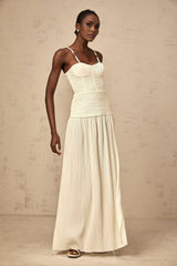 A long neutralcolored maxi dress with side slits and pleated details named Felicie