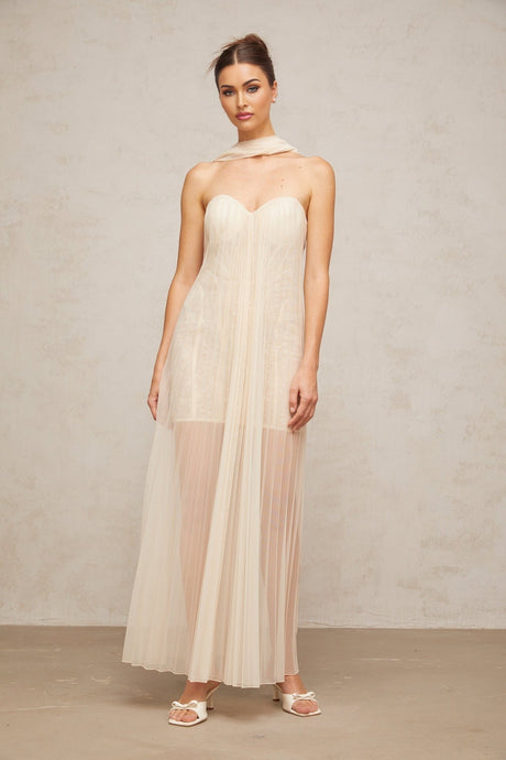 A long neutralcolored tulle maxi dress with pleats and ribbon design details