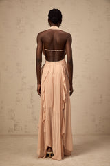 A long pink chiffon maxi dress with a halter neck and ruffle details worn by a model standing against a plain background