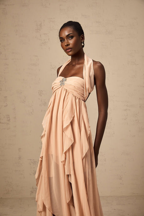 A long pink chiffon maxi dress with a halter neck and ruffle details
