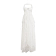 A long pink chiffon maxi dress with a halter neck and ruffled details worn by a model standing against a plain background