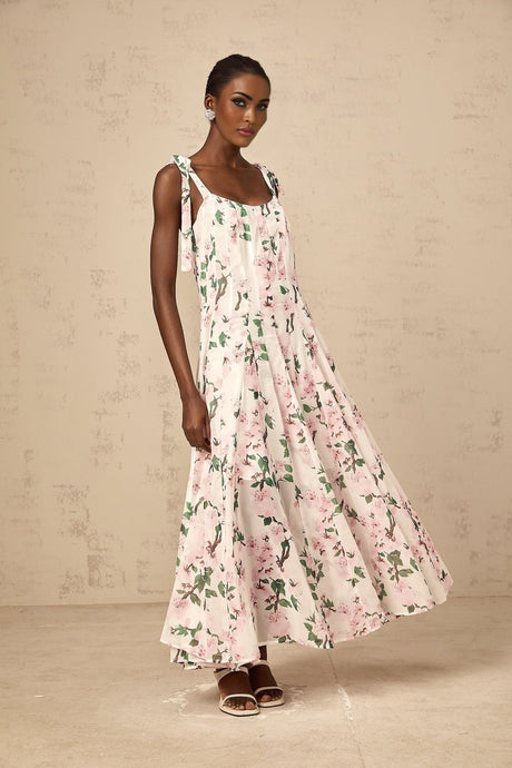 A long pink maxi dress with a floral print pattern and tied straps