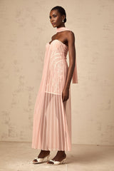 A long pink maxi dress with a pleated tulle skirt and ribbon design details on the bodice