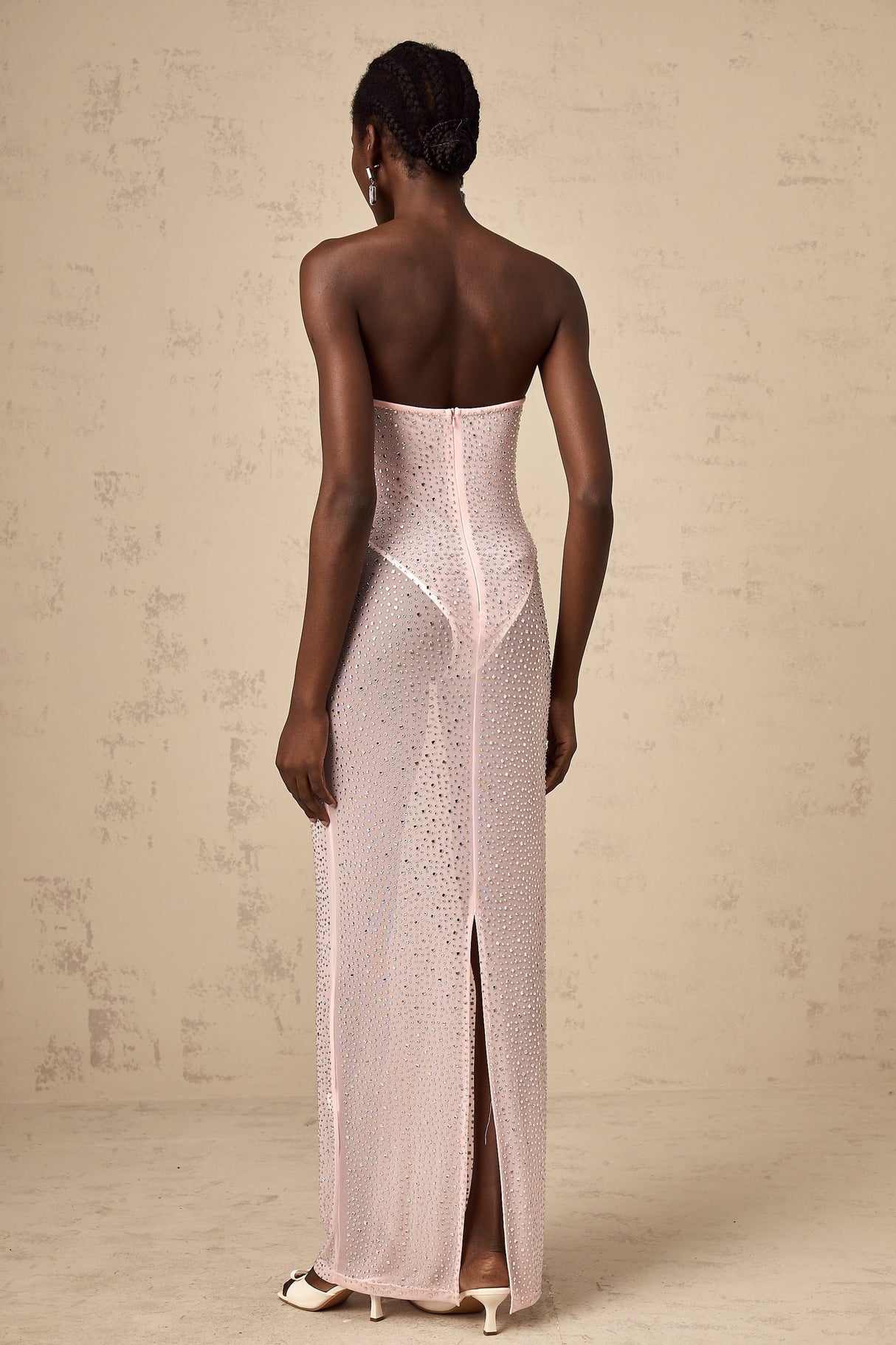 A long pink maxi dress with a semisheer fabric adorned with sparkling rhinestone embellishments featuring a flowing silhouette and elegant design