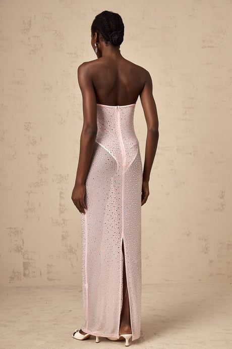 A long pink maxi dress with a semisheer fabric adorned with sparkling rhinestone embellishments featuring a flowing silhouette and elegant design