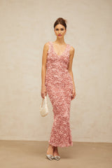 A long pink maxi dress with a Vneck and floral pattern featuring faux flowers throughout the fabric