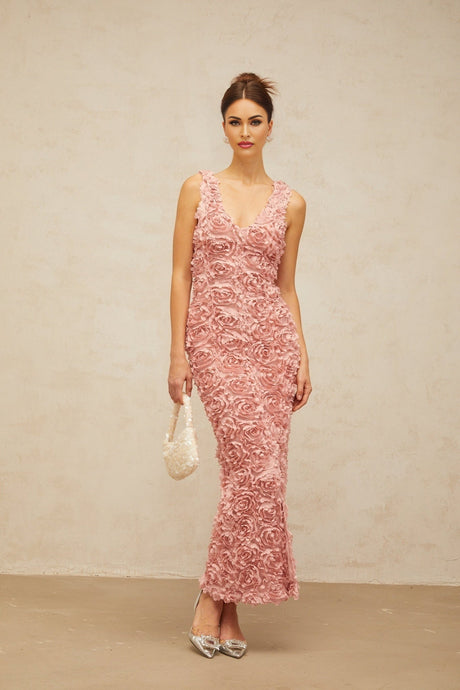A long pink maxi dress with a Vneck and floral pattern featuring faux flowers throughout the fabric
