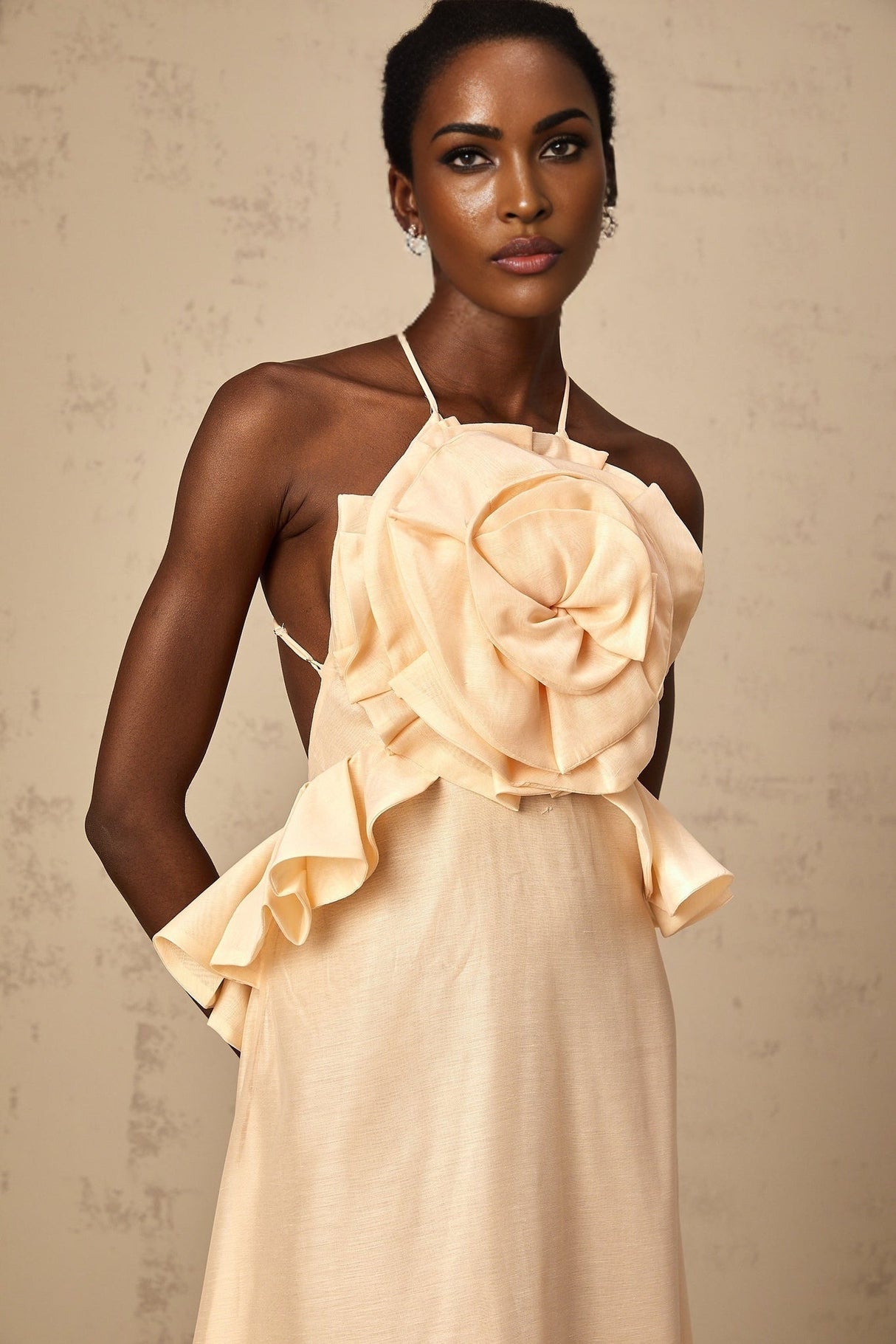 A long pink maxi dress with cascading 3D petal ruffles creating a romantic and feminine silhouette