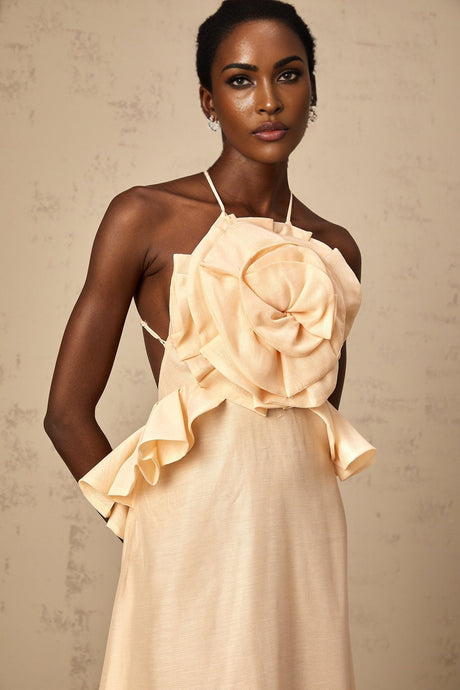 A long pink maxi dress with cascading 3D petal ruffles creating a romantic and feminine silhouette