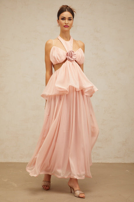 A long pink maxi dress with floral applique details and cut out sections featuring a feminine silhouette and delicate design
