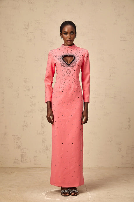 A long pink maxi dress with heart shaped cutouts and embellishments