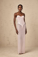 A long pink maxi dress with rhinestone embellishments and a semi sheer design featuring a flowing silhouette and sparkling details throughout