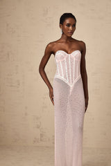 A long pink maxi dress with rhinestone embellishments and sheer elements featuring a flowing silhouette and delicate details