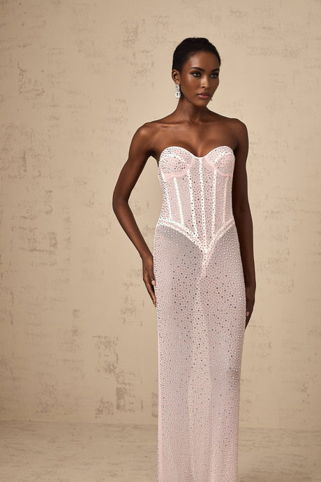 A long pink maxi dress with rhinestone embellishments and sheer elements featuring a flowing silhouette and delicate details