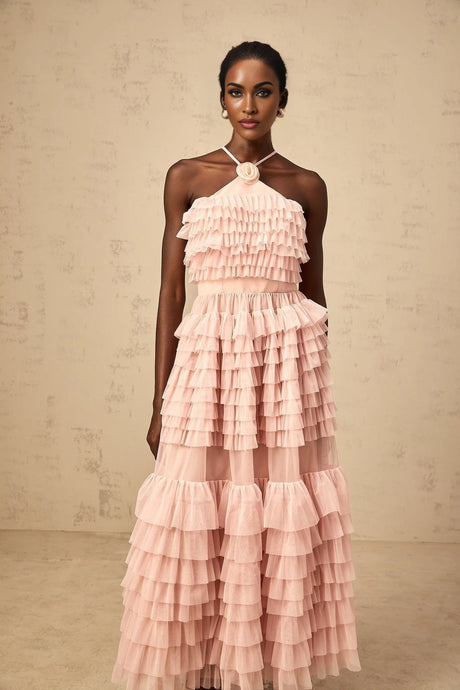 A long pink maxi dress with ruffled tiered tulle skirt and floral petal brooch detail at the waist