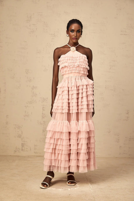 A long pink maxi dress with ruffled tiered tulle skirt and floral petal brooch detail