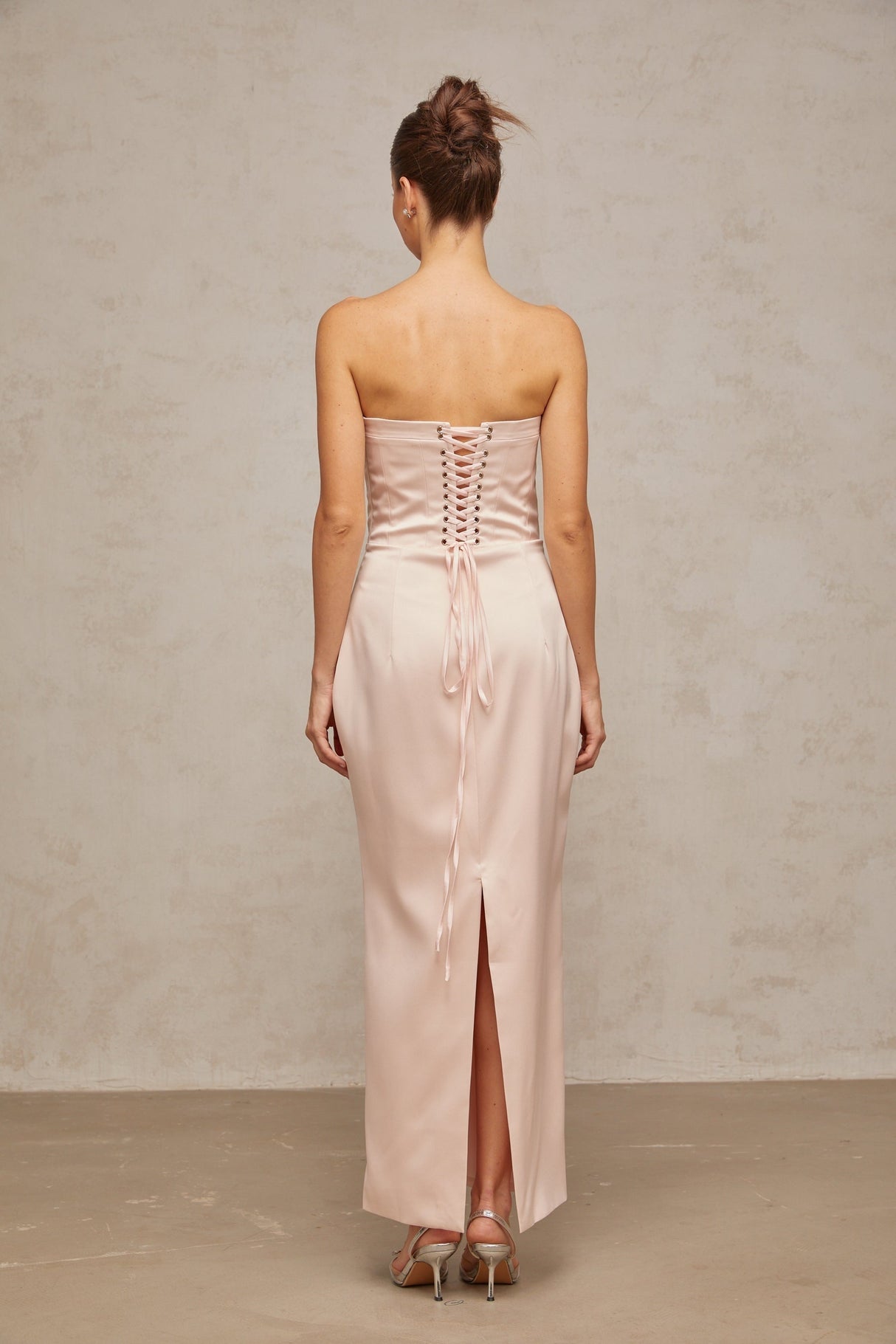 A long pink satin maxi dress with an offshoulder corset style bodice