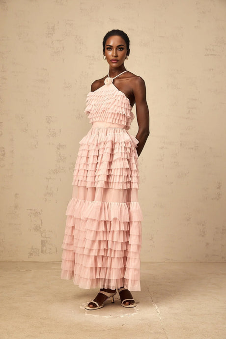 A long pink tiered tulle maxi dress with ruffles and a floral brooch accent at the waist