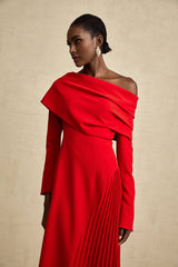 A long red maxi dress with a high slit and pleated skirt perfect for Valentines Day featuring a fitted bodice and flowing design