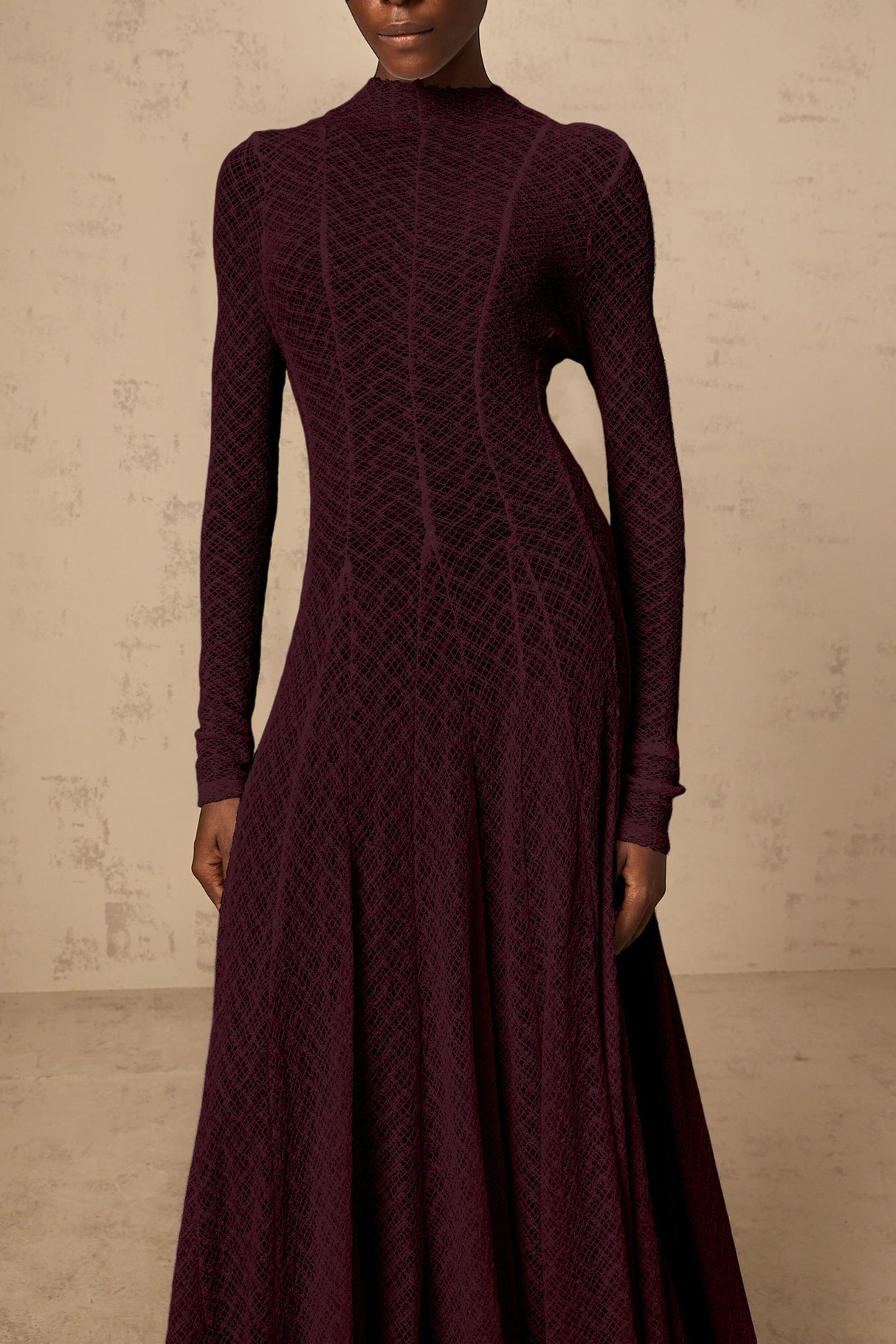 A long red maxi dress with a wavy lace pattern covering the entire garment The dress features a feminine silhouette and delicate detailing