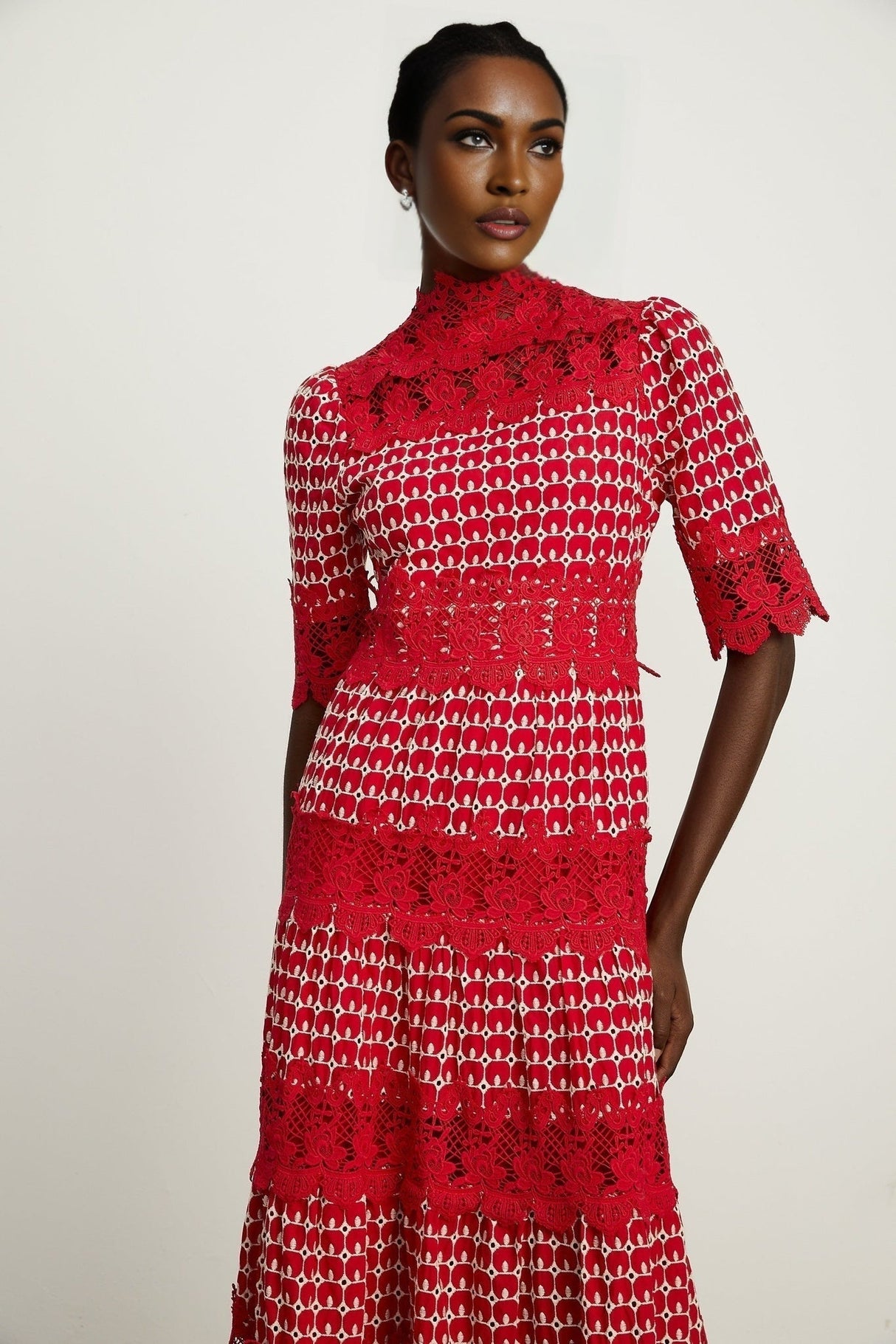 A long red maxi dress with scalloped lace panels and a feminine silhouette