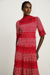 A long red maxi dress with scalloped lace panels and a feminine silhouette