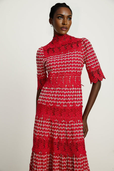 A long red maxi dress with scalloped lace panels and a feminine silhouette