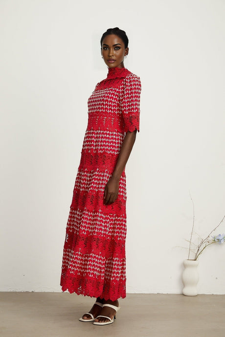 A long red maxi dress with scalloped lace panels featuring a delicate floral pattern