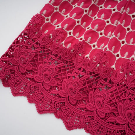 A long red maxi dress with scalloped lace panels featuring a delicate pattern throughout