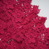 A long red maxi dress with scalloped lace panels featuring a delicate pattern