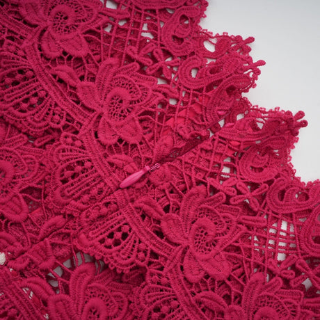 A long red maxi dress with scalloped lace panels featuring a delicate pattern