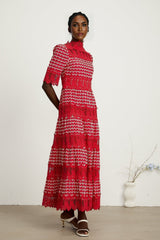 A long red maxi dress with scalloped lace panels featuring a delicate pattern