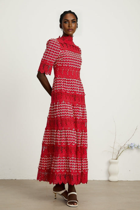 A long red maxi dress with scalloped lace panels featuring a delicate pattern