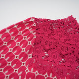 A long red maxi dress with scalloped lace panels featuring a floral pattern The dress has a fitted bodice and flows into a full length skirt