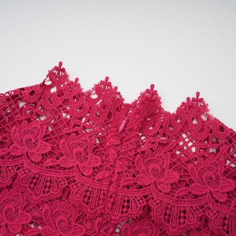 A long red maxi dress with scalloped lace panels featuring a floral pattern