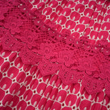 A long red maxi dress with scalloped lace panels featuring a floral pattern