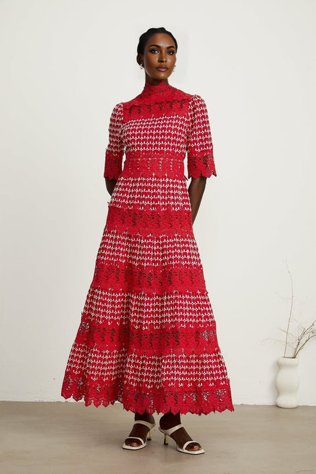 A long red maxi dress with scalloped lace panels featuring a floral pattern