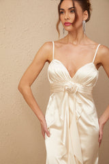 A long satin maxi dress in white with a corset bodice featuring colorful floral applique details and a flowing skirt