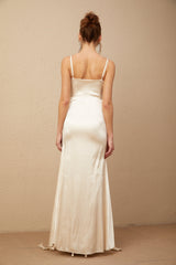 A long satin maxi dress with a corset bodice featuring floral applique details and a flowing skirt in a light color