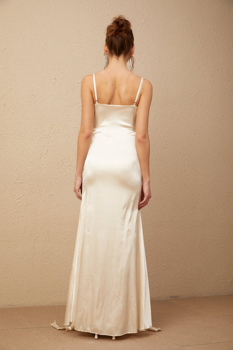 A long satin maxi dress with a corset bodice featuring floral applique details and a flowing skirt in a light color