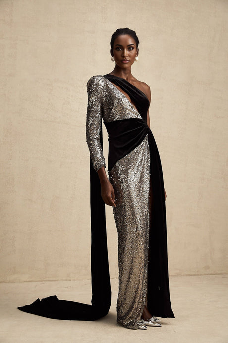 A long sequined maxi dress with an asymmetric hem featuring a shimmering Juliette style design