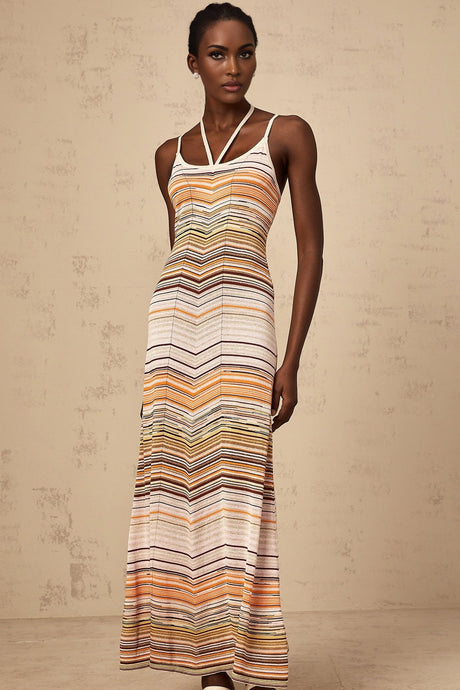 A long sleeveless knit dress with vertical multicolored stripes in pastel shades featuring a fitted bodice and flowing maxi skirt